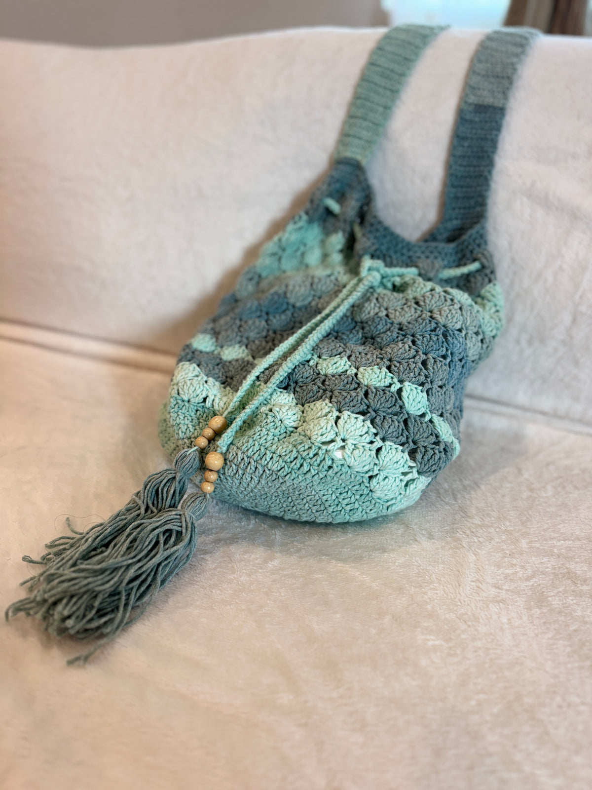 Seaglass green crochet drawstring shoulder bag with tassel, handmade by The Crochet Corral